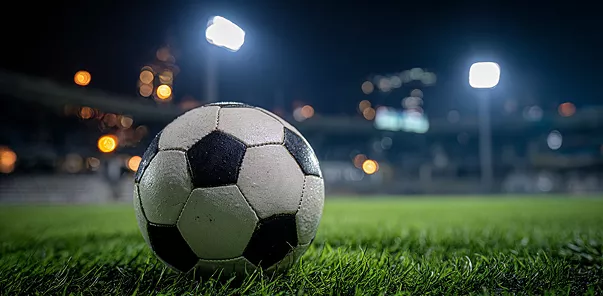 मैदान पर क्लोज़अप फुटबॉल के साथ 1xBet लोगो